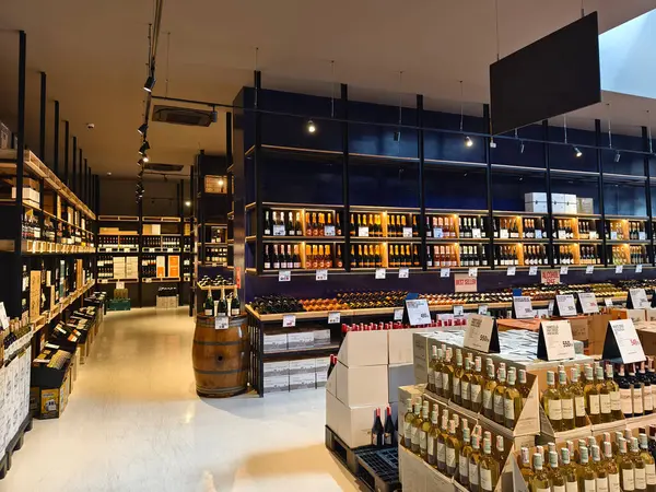Çok sayıda şarap şişesi ve kutu bulunan geniş bir mağaza..
