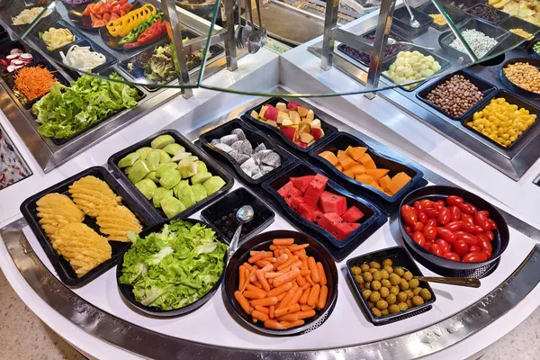 Bol miktarda taze sebze ve meyve içeren bir salata barı..