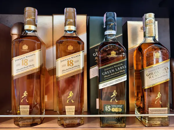 PHUKET, THAILAND - 8 Mart 2025: Bir süpermarketteki rafta Johnnie Walker 'ın viski şişeleri.