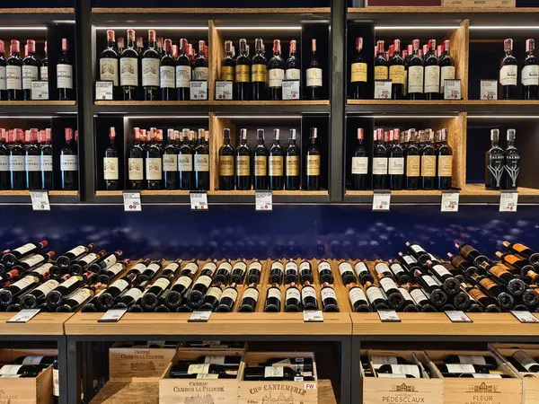 PHUKET, THAILAND - 8 Mart 2025: Çok sayıda şarap şişesi ve kutu içeren bir mağaza.