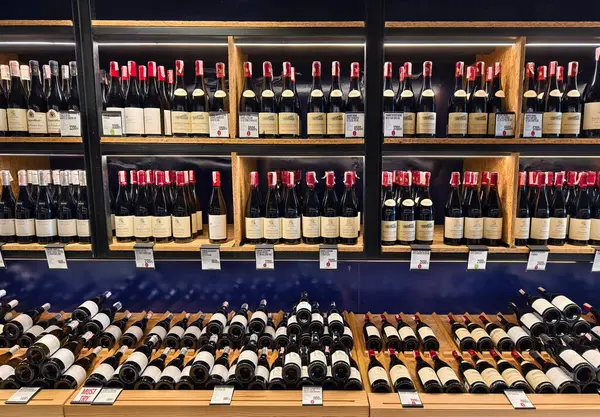 PHUKET, THAILAND - 8 Mart 2025: Çok sayıda şarap şişesi ve kutu içeren bir mağaza.