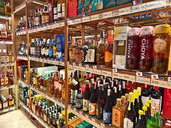 PHUKET, THAILAND - 8 Mart 2025: sayısız çeşitli alkol şişeleriyle dolu bir perakende mağazası.