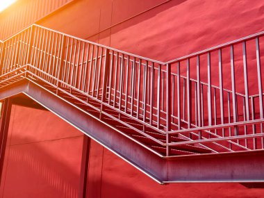 Büyük kırmızı bir duvara tırmanan bir merdiven seti..