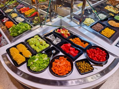 Bol miktarda taze sebze ve meyve içeren bir salata barı..