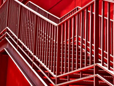 Büyük kırmızı bir duvara tırmanan bir merdiven seti..