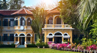 Geniş, sarı bir ev, büyük bir parkla çevrili..