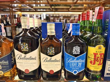 PHUKET, THAILAND - 8 Mart 2025: sayısız çeşitli alkol şişeleriyle dolu bir perakende mağazası.