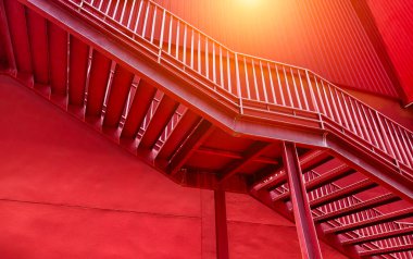 Büyük kırmızı bir duvara tırmanan bir merdiven seti..