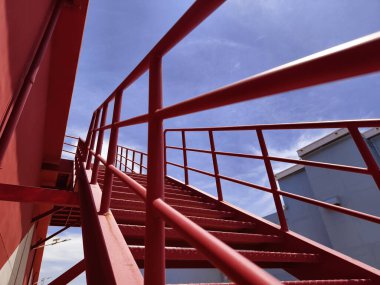 Büyük kırmızı bir duvara tırmanan bir merdiven seti..