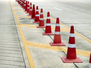 Bir sıra kırmızı ve beyaz trafik konisi bir yol tarafından yerleştirilir..