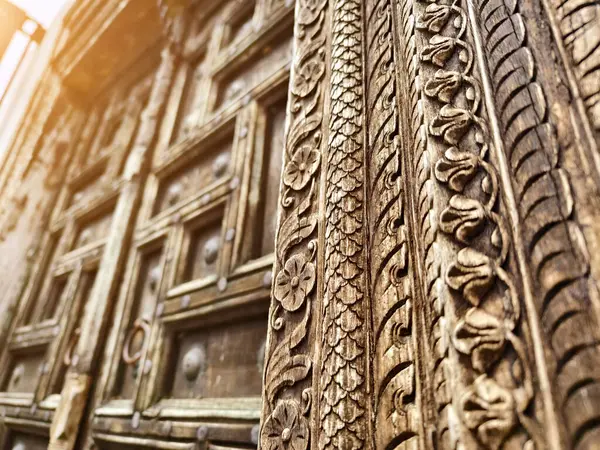 Zarif metal yüzüklerle süslenmiş antik ahşap bir kapının ayrıntılı görüntüsü.