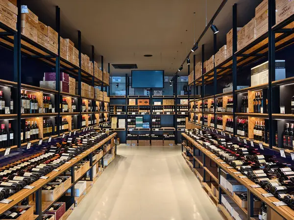 Çok sayıda şarap şişesi ve kutu bulunan geniş bir mağaza..
