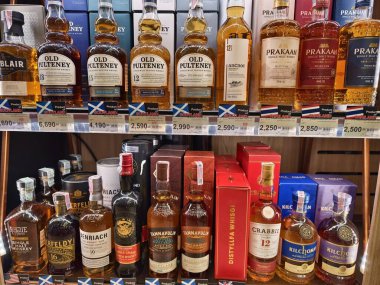 PHUKET, THAILAND - 8 Mart 2025: sayısız çeşitli alkol şişeleriyle dolu bir perakende mağazası.