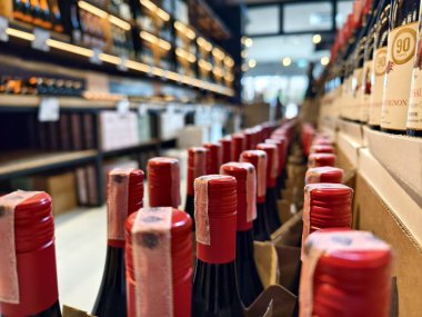 Bir mağaza rafında düzgünce düzenlenmiş bir sürü şarap şişesi..