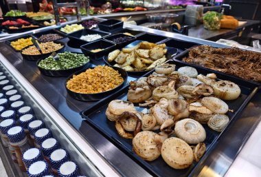 Bol miktarda taze sebze ve meyve içeren bir salata barı..