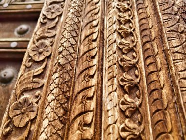 Zarif metal yüzüklerle süslenmiş antik ahşap bir kapının ayrıntılı görüntüsü.