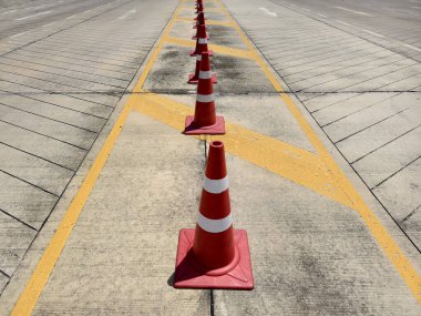 Bir sıra kırmızı ve beyaz trafik konisi bir yol tarafından yerleştirilir..