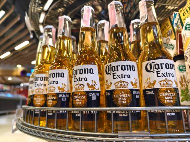 PHUKET, THAILAND - 8 Mart 2025: Corona biraları düzgünce bir rafa dizildi.