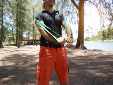 Genç çift parkta direniş bantlarıyla egzersiz yapıyor..