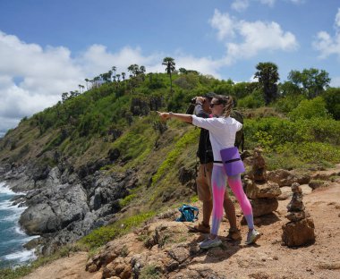 Bir erkek ve bir kadın dikkatle dürbünle uzaktan ilginç bir şeye bakıyorlar..