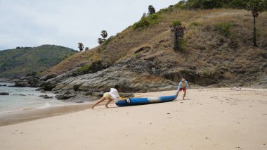 Genç bir çift deniz yolculuğundan sonra sudan bir kano çıkarıyorlar..