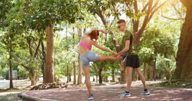 Bir adam ve bir kadın parkta birlikte koştuktan sonra bacaklarını açıyorlar..