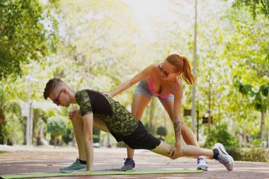 Bir adam ve bir kadın parkta birlikte koştuktan sonra bacaklarını açıyorlar..