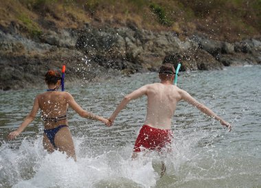 Bir adam ve bir kadın gözlük takıyor ve suyun tadını çıkarıyorlar..