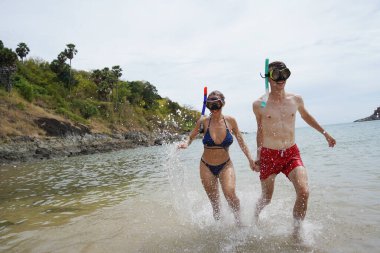Bir adam ve bir kadın gözlük takıyor ve suyun tadını çıkarıyorlar..