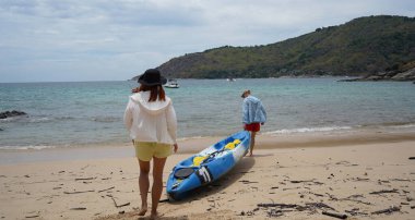 Genç bir çift deniz yolculuğu için mavi bir kano fırlatıyor..