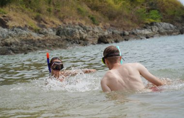 Bir adam ve bir kadın gözlük takıyor ve suyun tadını çıkarıyorlar..