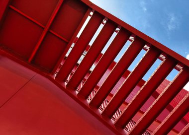 Büyük kırmızı bir duvara tırmanan bir merdiven seti..