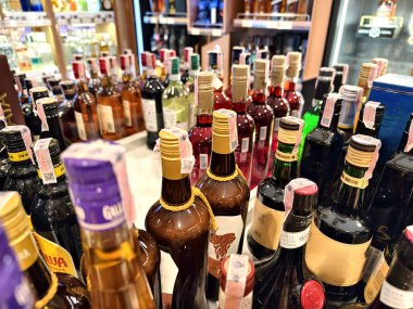 PHUKET, THAILAND - 8 Mart 2025: sayısız çeşitli alkol şişeleriyle dolu bir perakende mağazası.