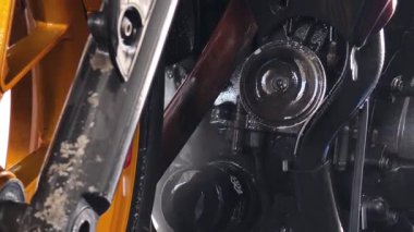 Bir motosiklet titiz bir temizlikten geçer, göz kamaştırıcı altın tekerleklerini vurgular..