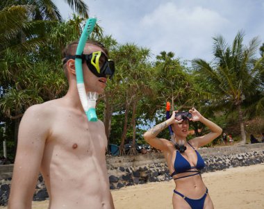 Bir adam ve bir kadın gözlük takıyor ve suyun tadını çıkarıyorlar..