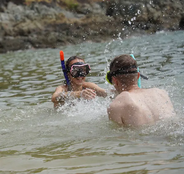Bir adam ve bir kadın gözlük takıyor ve suyun tadını çıkarıyorlar..