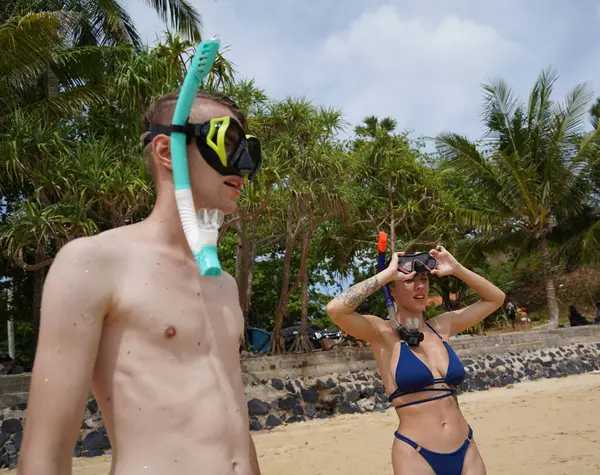 Bir adam ve bir kadın gözlük takıyor ve suyun tadını çıkarıyorlar..