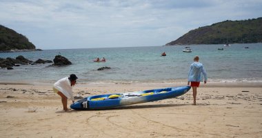 Genç bir çift deniz yolculuğu için mavi bir kano fırlatıyor..