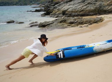 Genç bir çift deniz yolculuğundan sonra sudan bir kano çıkarıyorlar..