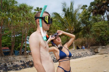 Bir adam ve bir kadın gözlük takıyor ve suyun tadını çıkarıyorlar..