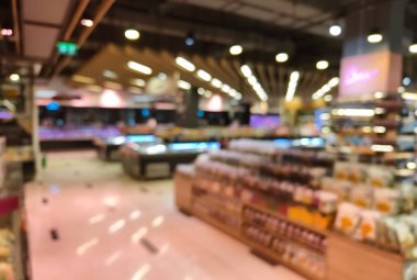 Birçok rafı ve ekranı olan bir marketin bulanık görüntüsü.
