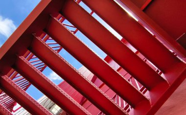 Büyük kırmızı bir duvara tırmanan bir merdiven seti..