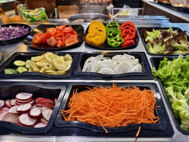 Bol miktarda taze sebze ve meyve içeren bir salata barı..