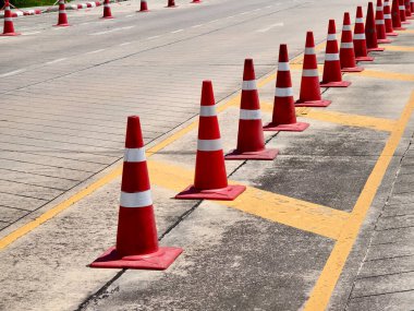 Bir sıra kırmızı ve beyaz trafik konisi bir yol tarafından yerleştirilir..