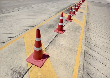 Bir sıra kırmızı ve beyaz trafik konisi bir yol tarafından yerleştirilir..