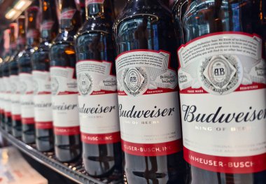 PHUKET, THAILAND - 8 Mart 2025: Budweiser biraları düzgünce bir rafa dizildi.