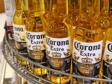PHUKET, THAILAND - 8 Mart 2025: Corona biraları düzgünce bir rafa dizildi.