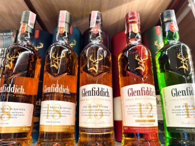 PHUKET, THAILAND - 8 Mart 2025: Bir süpermarkette raftaki viski şişeleri The Glenfiddich.
