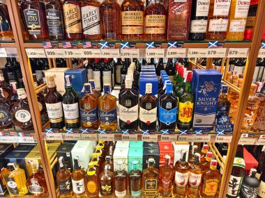 PHUKET, THAILAND - 8 Mart 2025: sayısız çeşitli alkol şişeleriyle dolu bir perakende mağazası.