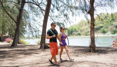 Genç çift parkta direniş bantlarıyla egzersiz yapıyor..